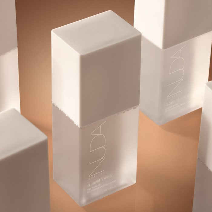 Minimalist frosted glass bottle with white cap containing Cloudmist Express - Face Tan Water | NUDA, a skincare product designed for a natural tan and radiant glow.