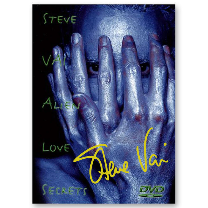 A person with metallic blue-painted skin covers most of their face with their hands. Green text reads Steve Vai Alien Love Secrets. A yellow signature highlights this Signed DVD from Steve Vai, with only the eyes visible above the logo.