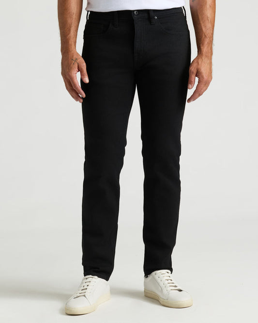 Black Wash Slim Authentic Denim Jeans with white sneakers on a light background.