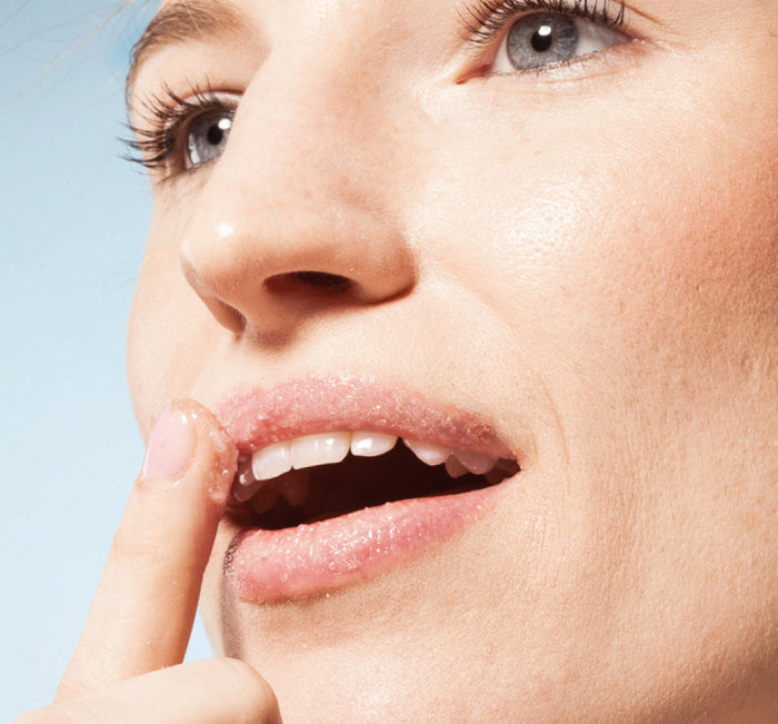 Close-up of a woman applying Blackberry Wine Lip Polish | Farmhouse Fresh to her lips, highlighting natural skincare and lip care for a smooth, polished look.
