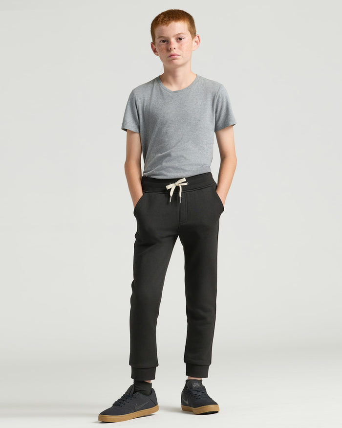 Boys' Black Fleece Jogger on boy with hands in pockets.