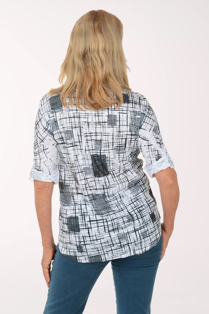 Woman wearing a checkered blouse and blue jeans on a white background