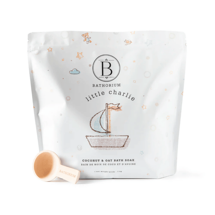Package of little charlie™ Kids Bath Soak 250g | Bathorium with a small wooden scoop, featuring playful illustrations of a sailboat, stars, and clouds for a gentle skincare bath soak.