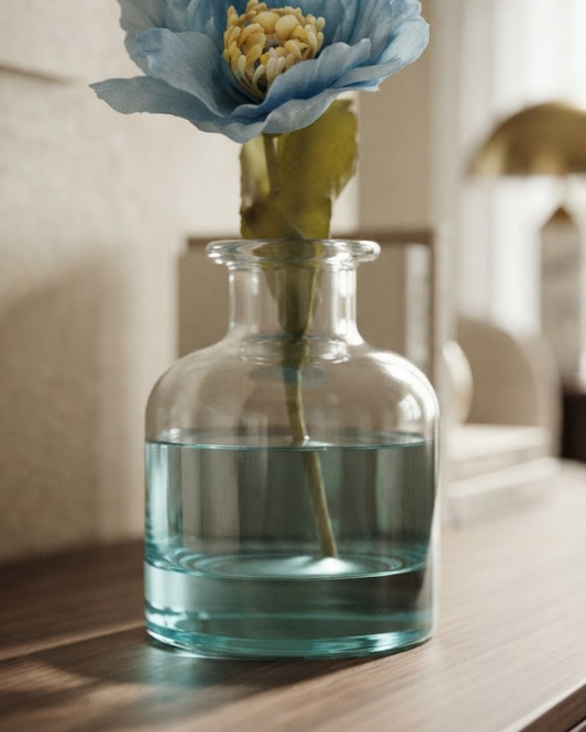 Blue-tinted glass bottle reed diffuser with blue flower bloom