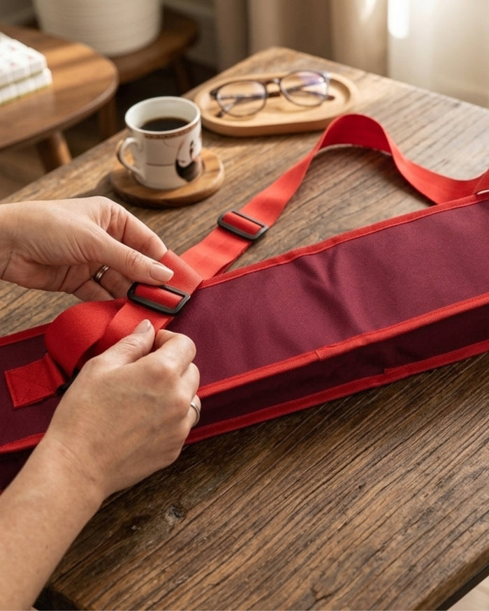 Red mahjong mat carry bag being secured with buckle strap at a table