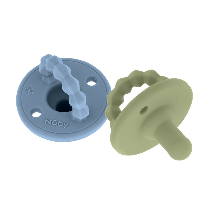 The Nuby Silicone Softees Pacifier & Teether (2 Pack) features light blue and olive green silicone pacifiers with round shields and textured handles, ideal for soothing babies and gentle teething.