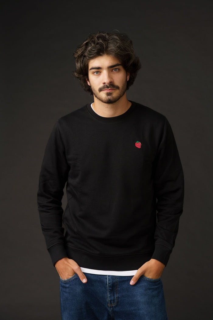 Embroidered strawberry detail on black sustainable sweatshirt made from organic cotton.