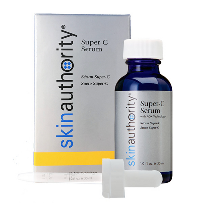 A blue glass bottle of Super-C Serum | Skin Authority with a white dropper cap next to its branded white and yellow packaging, highlighting skincare wellness.