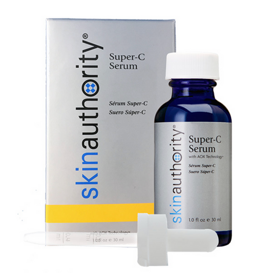 A blue glass bottle of Super-C Serum | Skin Authority with a white dropper cap next to its branded white and yellow packaging, highlighting skincare wellness.