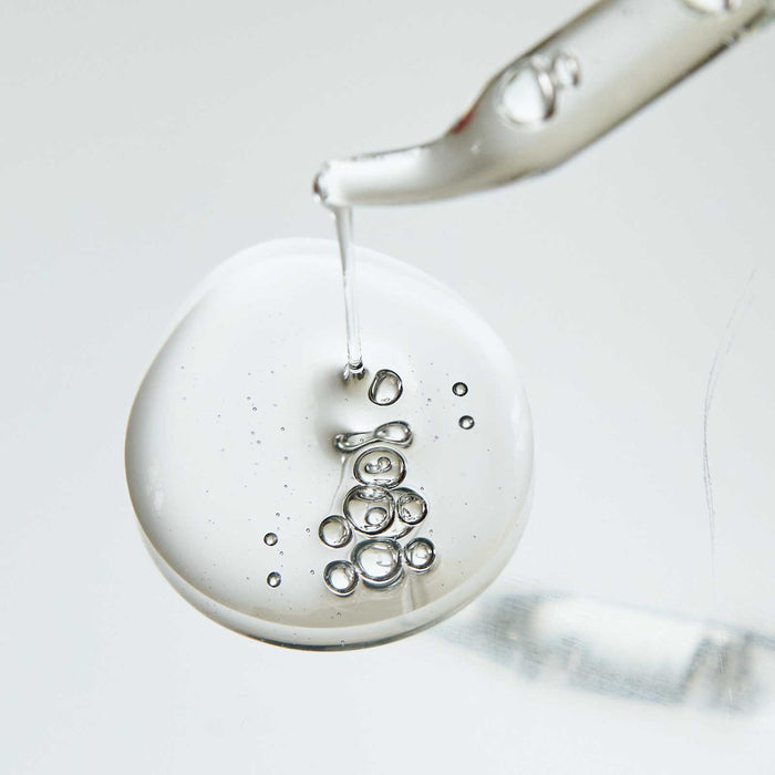 Close-up of clear serum with bubbles being dispensed from a dropper, representing Super-C Serum | Skin Authority for skincare and wellness.