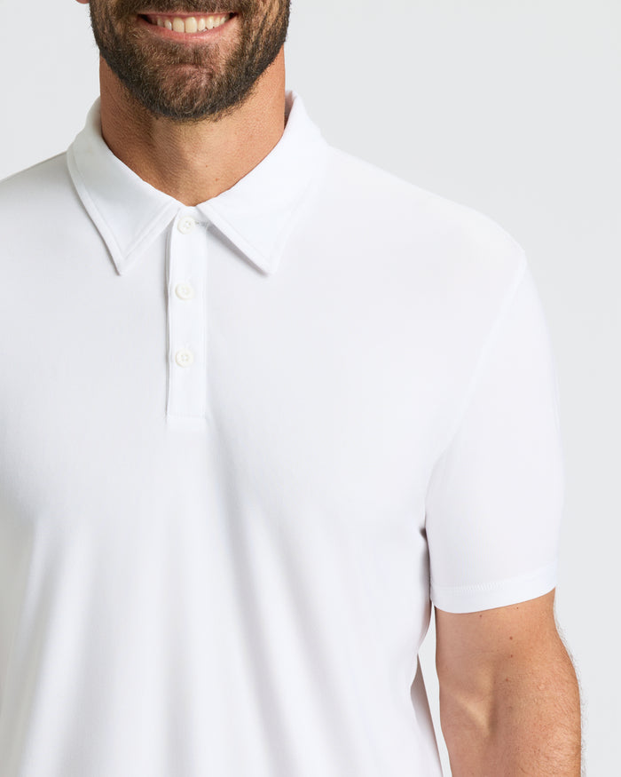 Man wearing White Active Polo with three-button placket, smiling.