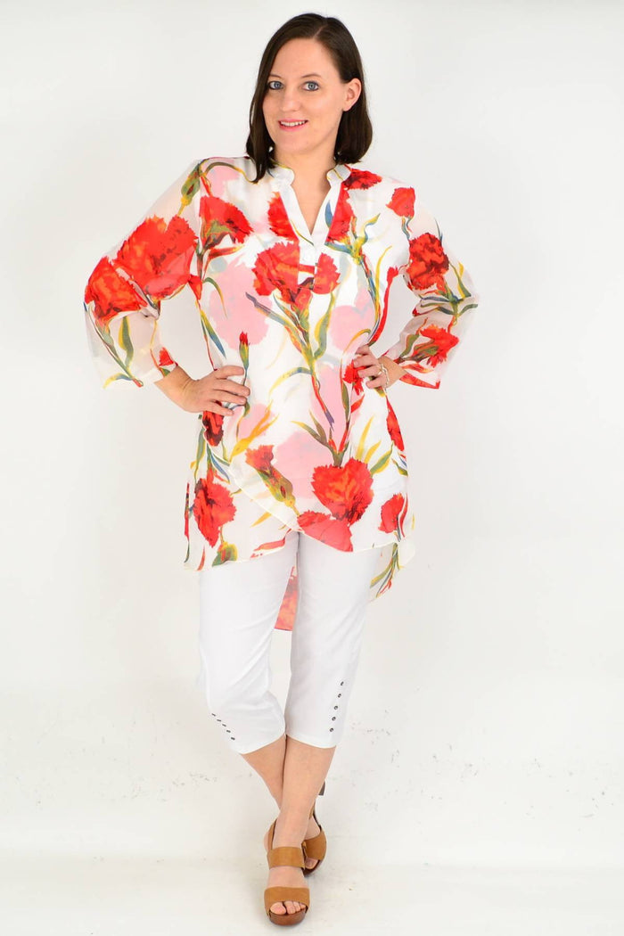 White floral button-up tunic shirt from whispers featuring long sleeves and a relaxed fit, displayed on a hanger.
