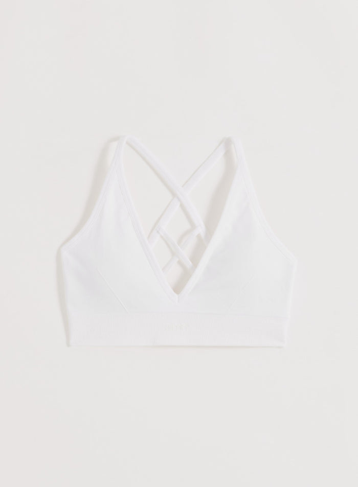 White seamless sports bra from aim'n featuring cross-back straps and a supportive ribbed underband.