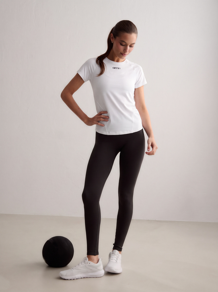 Model wearing a white Soft Basic Short Sleeve and black leggings with a medicine ball [S-174 cm]